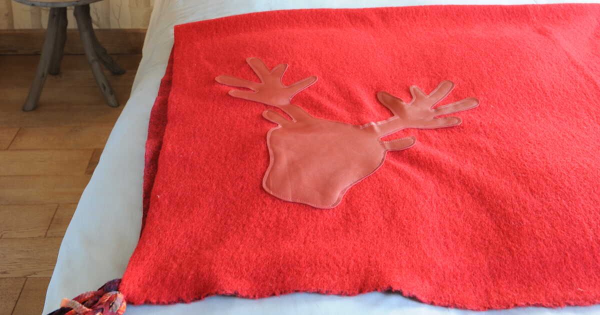 Un plaid à tête de cerf et pompons